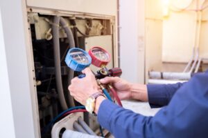 A technician holding two pipes, one red and one blue, while inspecting heating system gauges. The image represents the importance of timely heating installation for efficiency, reliability, and safety.